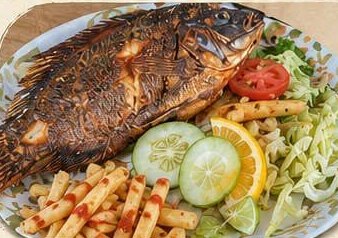 Mojarra frita servida con ensalada, papas y limón